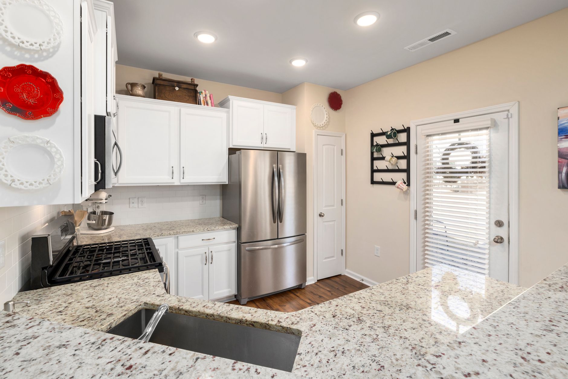 Stylish modern kitchen featuring white cabinets, granite countertops, and stainless steel appliances in Hendersonville, NC