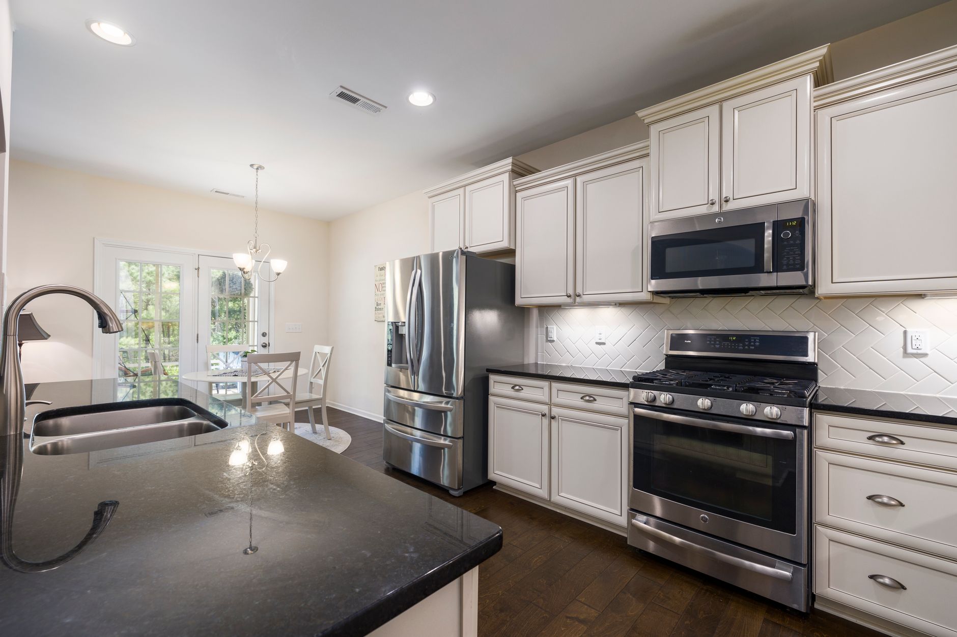 Bright modern kitchen featuring stainless steel appliances and dark countertops in Hendersonville, NC