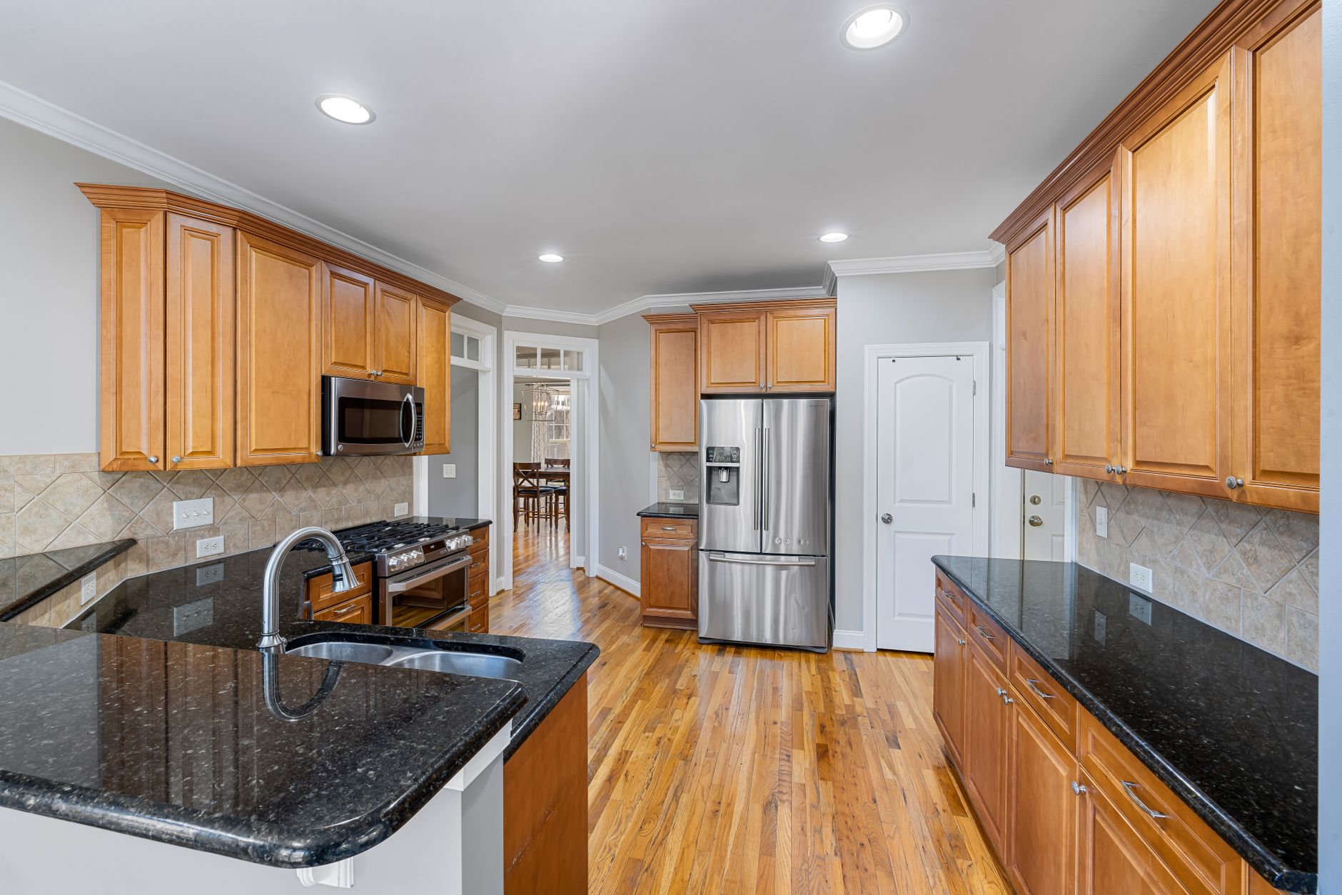 Spacious modern kitchen featuring granite countertops, wooden cabinets, and stainless steel appliances in Hendersonville, NC