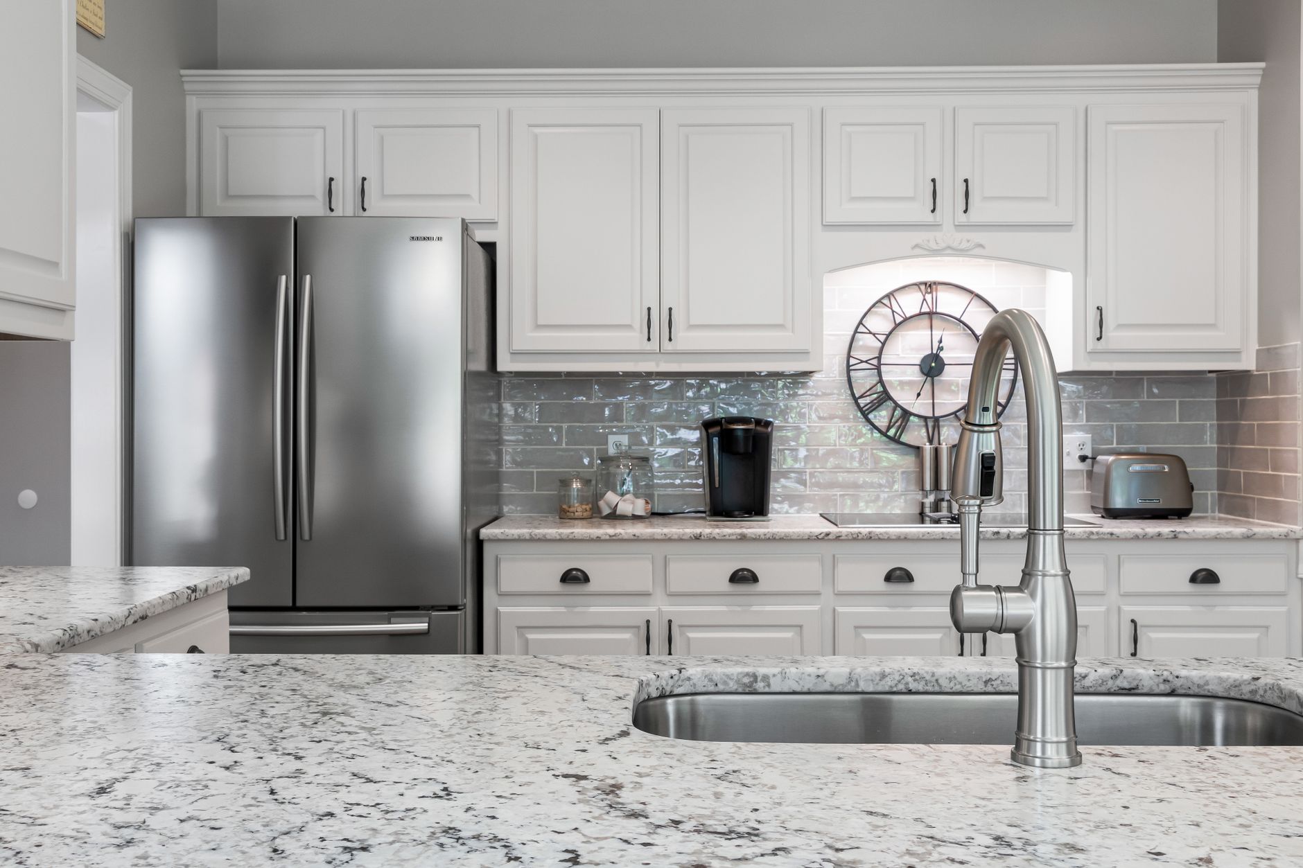Elegant white kitchen featuring stainless steel appliances, granite countertops, and modern design in Hendersonville, NC